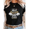 Women'WB shield "TNF MOST AWESOME DAD EVER" Graphic T-Shirt - Green Short Sleeve Crew Neck Casual Top with Thumbs-Up...